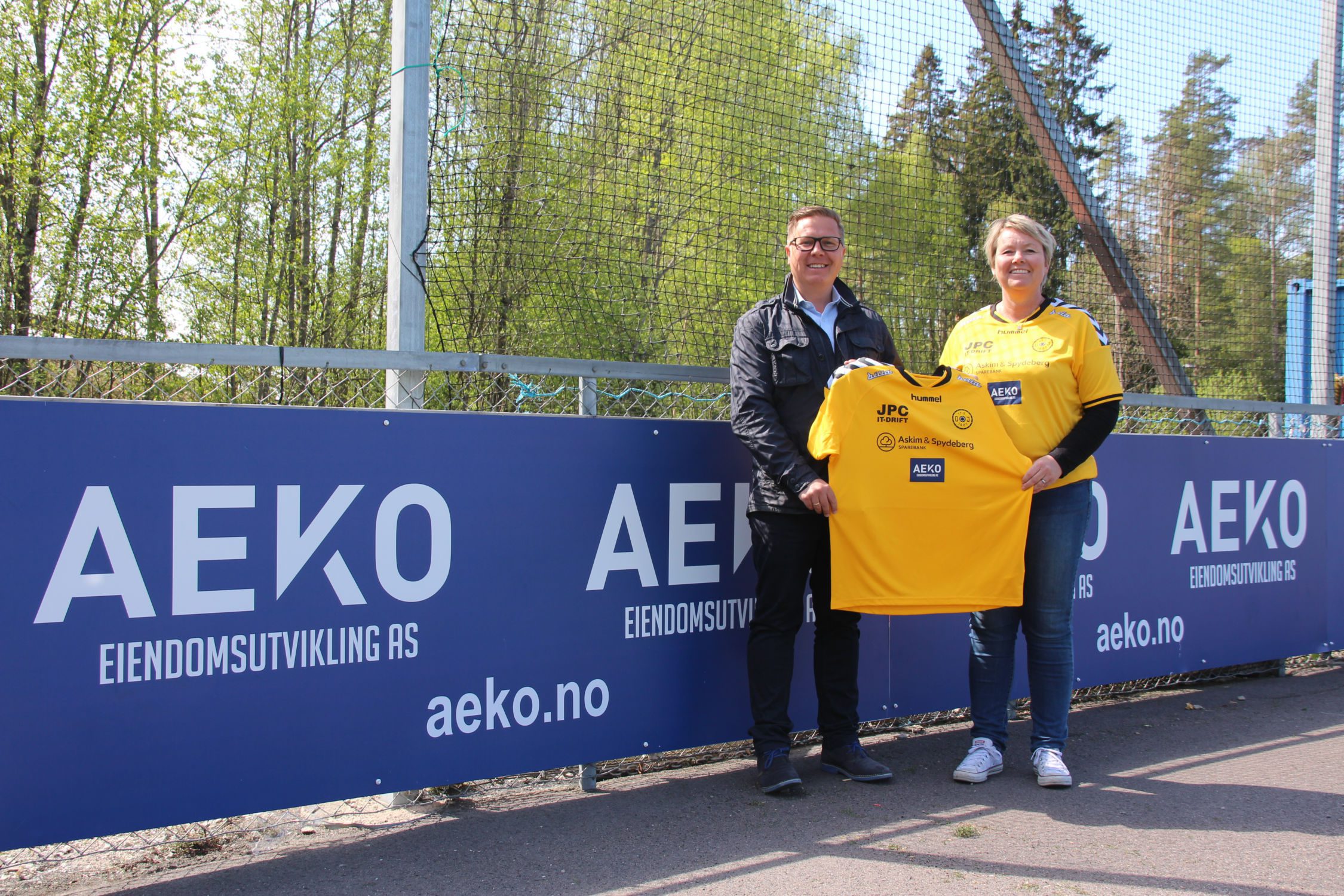 Dame og mann som holder gul fotballdrakt